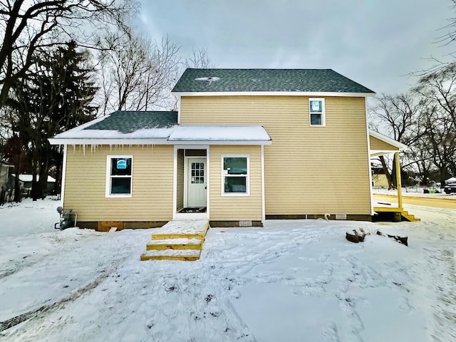 view of snow covered rear of property