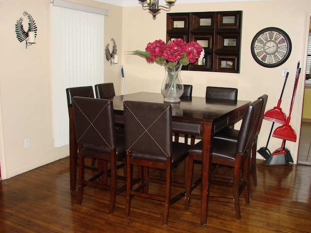 dining area with a notable chandelier and dark hardwood / wood-style floors