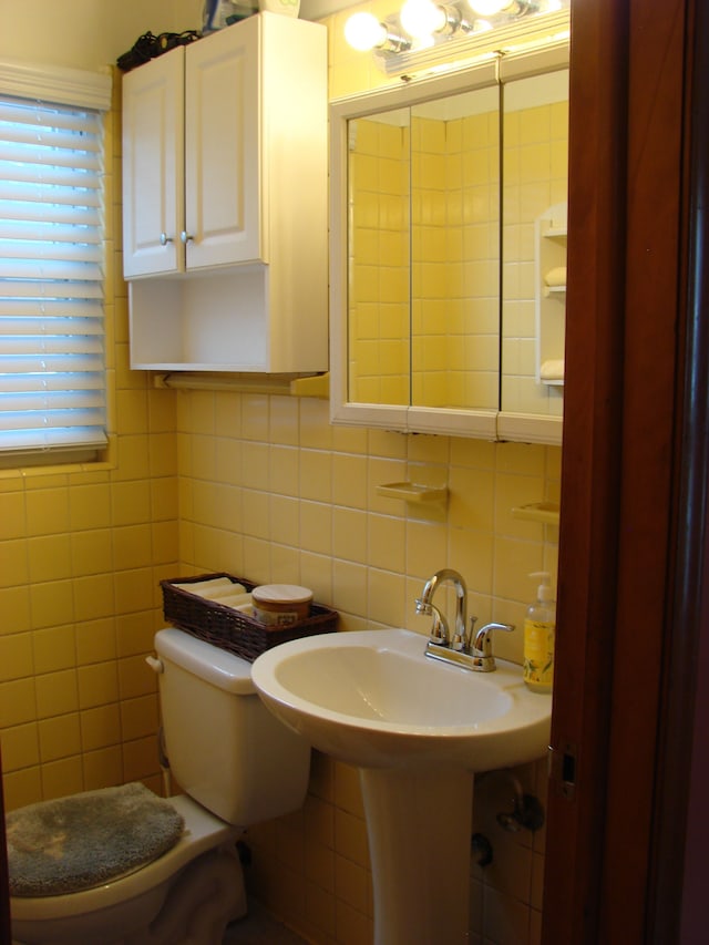 bathroom featuring backsplash, toilet, and tile walls