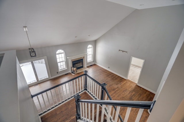 stairs with hardwood / wood-style flooring and lofted ceiling