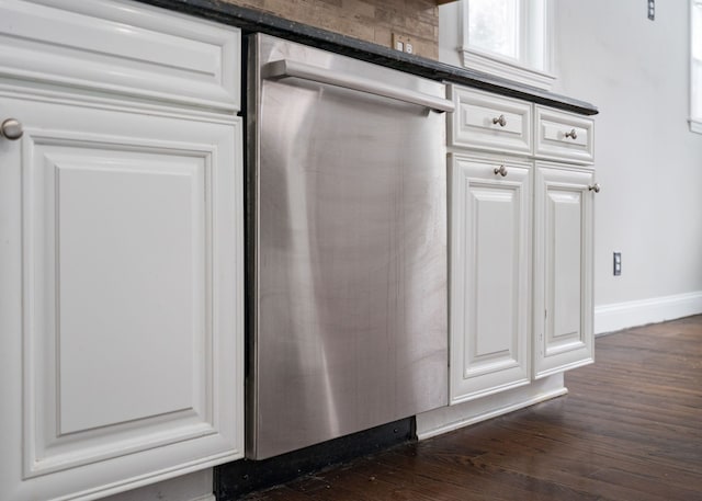 interior details featuring stainless steel dishwasher, white cabinetry, and dark wood-type flooring