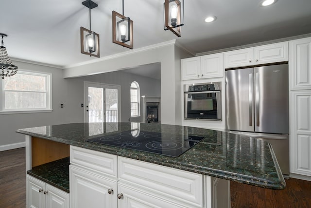 kitchen featuring dark stone countertops, hanging light fixtures, white cabinets, and stainless steel appliances