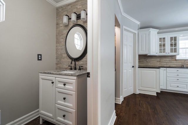 bathroom featuring backsplash, vanity, wood-type flooring, and crown molding