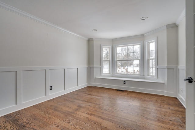 empty room with hardwood / wood-style floors and ornamental molding