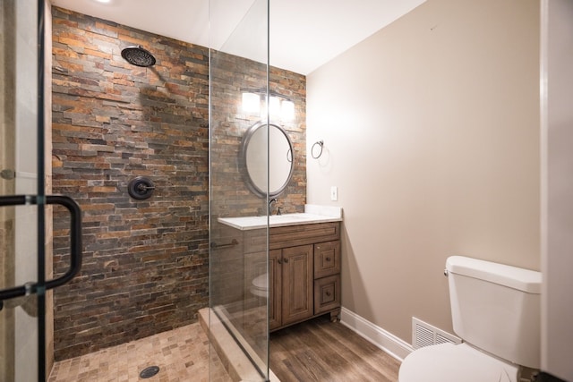 bathroom with vanity, toilet, a shower with door, and wood-type flooring