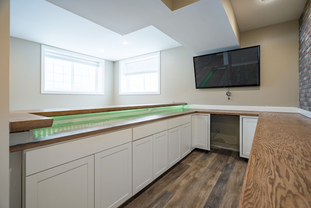 kitchen featuring white cabinetry, built in desk, and dark hardwood / wood-style floors