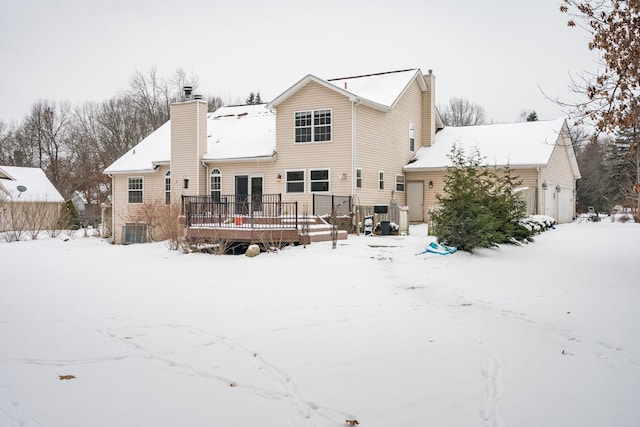 snow covered property with central AC and a deck