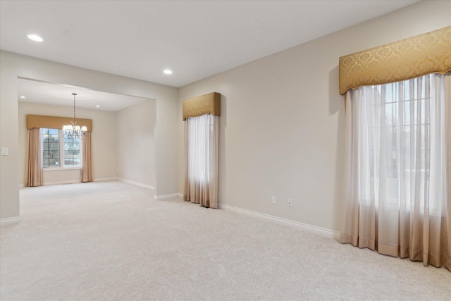 empty room with carpet floors, recessed lighting, baseboards, and an inviting chandelier