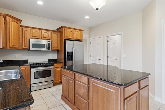 kitchen featuring light tile patterned floors, recessed lighting, a sink, appliances with stainless steel finishes, and a center island