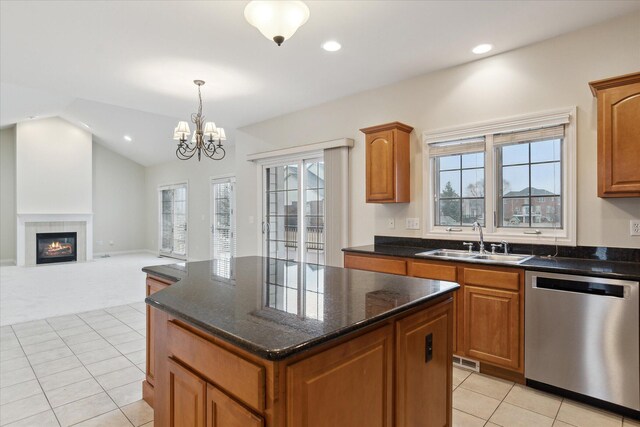 kitchen with lofted ceiling, a tile fireplace, a sink, a center island, and dishwasher