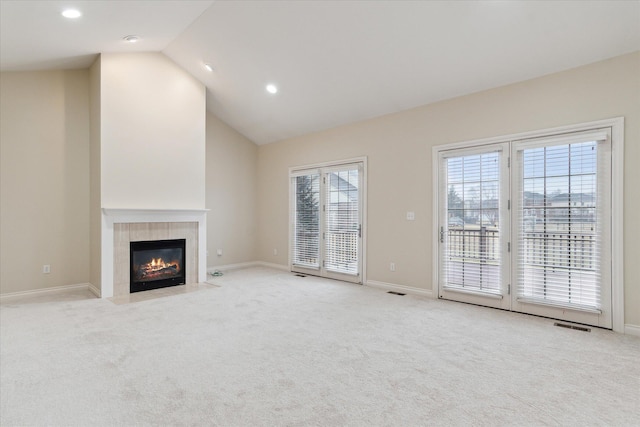 unfurnished living room featuring baseboards, a tile fireplace, light colored carpet, high vaulted ceiling, and recessed lighting