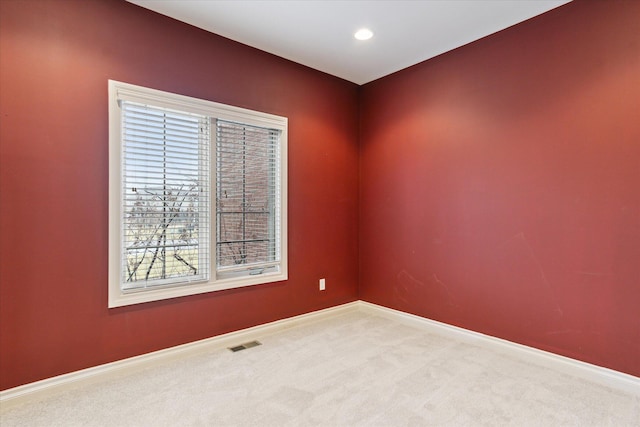 spare room with carpet floors, recessed lighting, visible vents, and baseboards