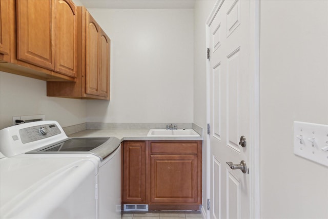 clothes washing area with cabinet space, light tile patterned floors, visible vents, separate washer and dryer, and a sink