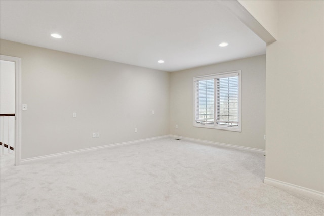 empty room featuring light carpet, baseboards, and recessed lighting