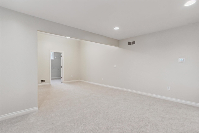 empty room featuring light colored carpet, recessed lighting, visible vents, and baseboards