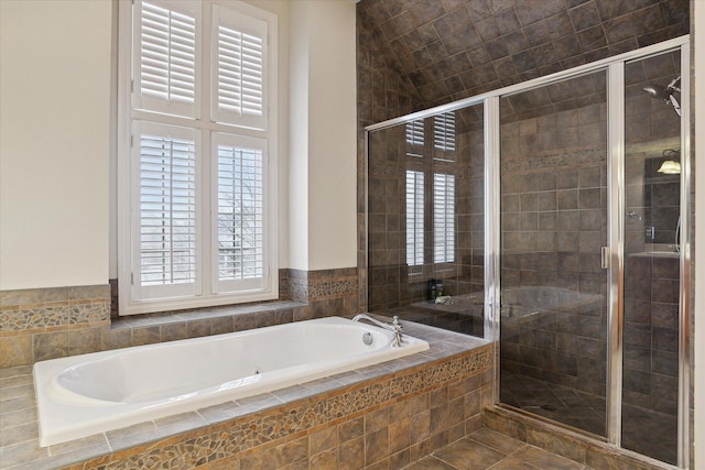 bathroom featuring a garden tub and a shower stall