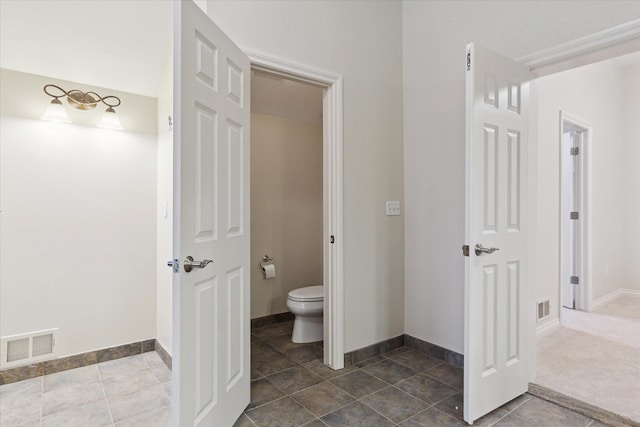 bathroom featuring baseboards, visible vents, and toilet