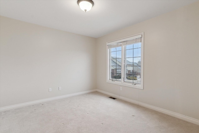 unfurnished room with light carpet, baseboards, and visible vents