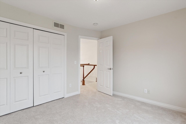 unfurnished bedroom with baseboards, a closet, visible vents, and light colored carpet