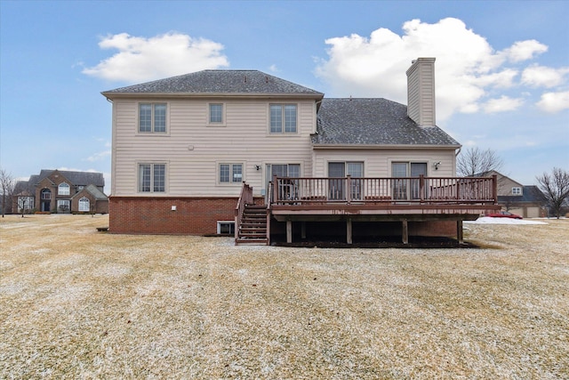 rear view of property with brick siding, a chimney, and a wooden deck