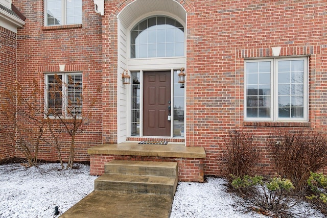 view of exterior entry with brick siding