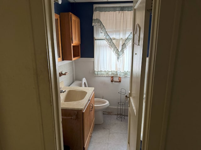 bathroom with toilet, vanity, and tile patterned floors