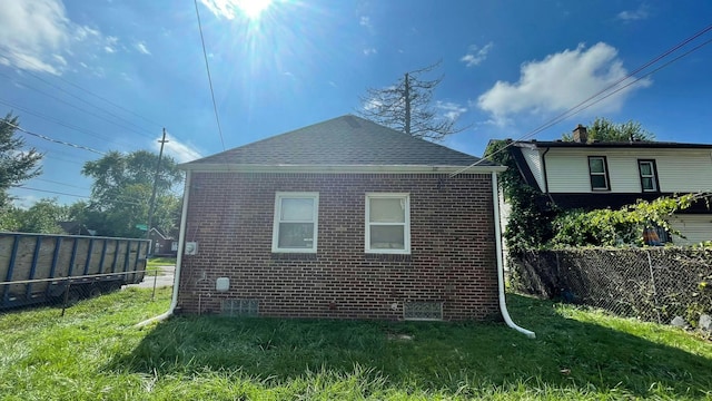 view of side of home with a yard