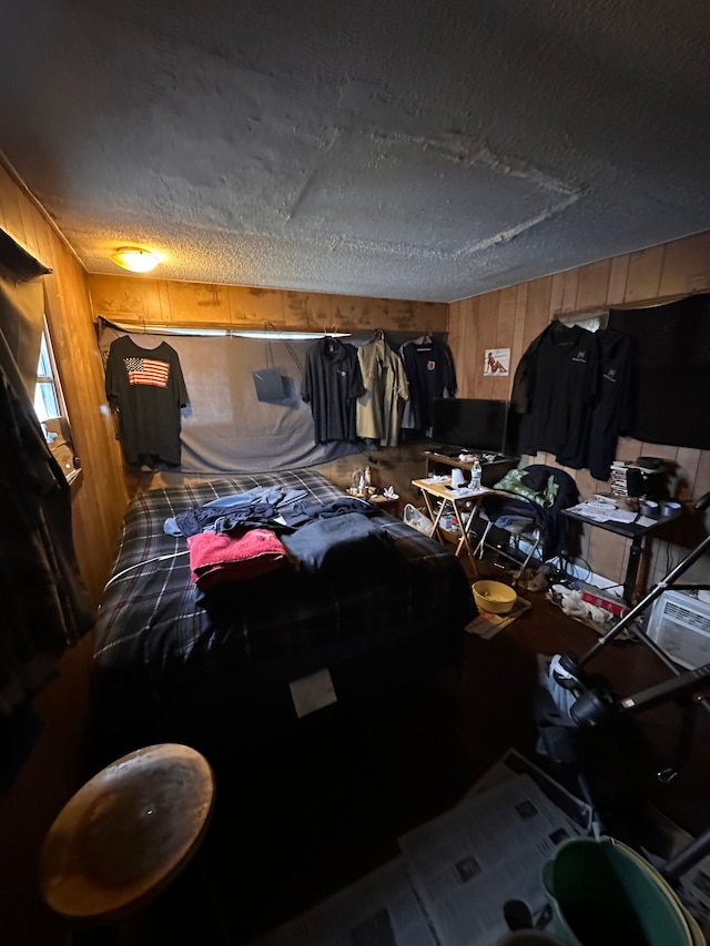 bedroom featuring wood walls and a textured ceiling