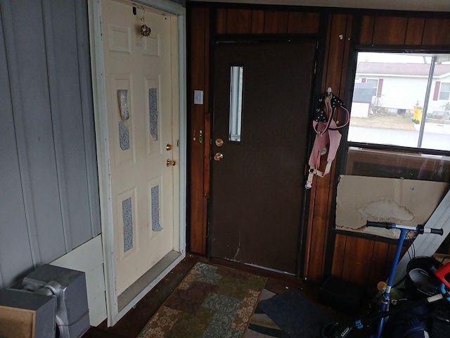 doorway to outside with wooden walls