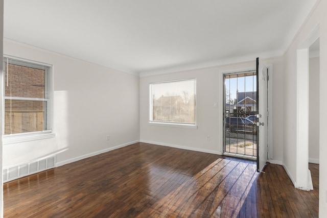 unfurnished room featuring dark wood-type flooring and ornamental molding