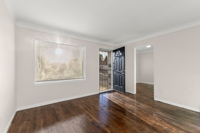 spare room with dark hardwood / wood-style floors, plenty of natural light, and crown molding