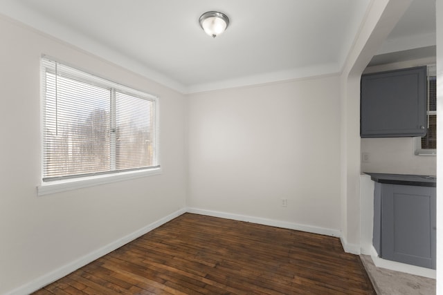 unfurnished dining area with dark wood-type flooring