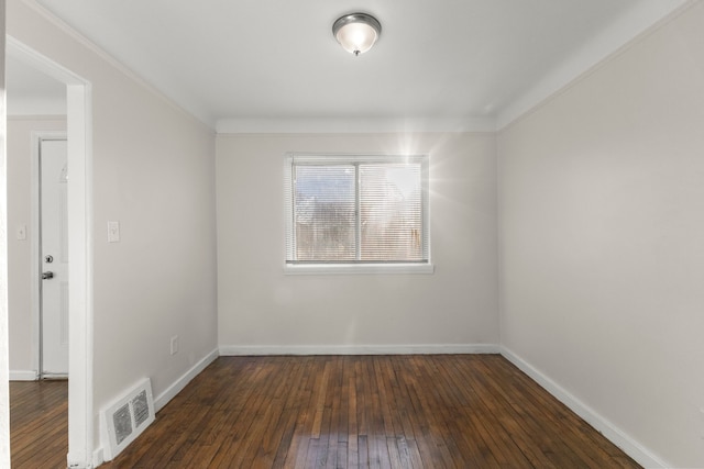 empty room featuring dark hardwood / wood-style floors and crown molding