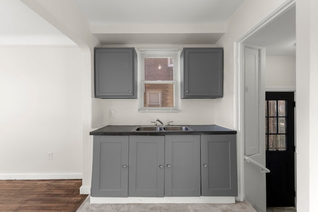 kitchen with gray cabinets, sink, and wood-type flooring