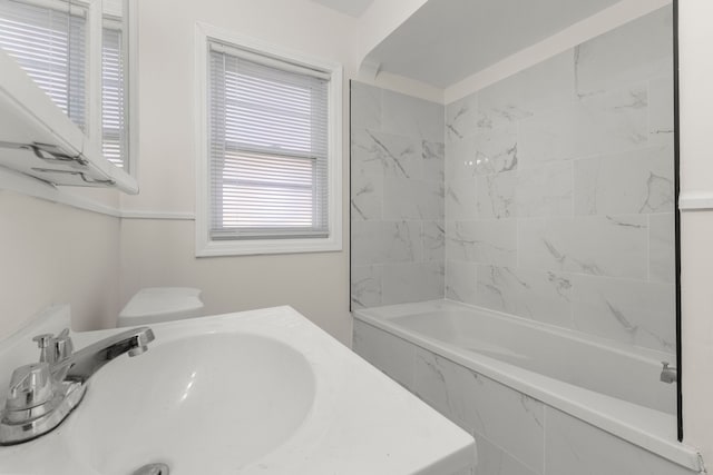 bathroom featuring tiled shower / bath combo and sink