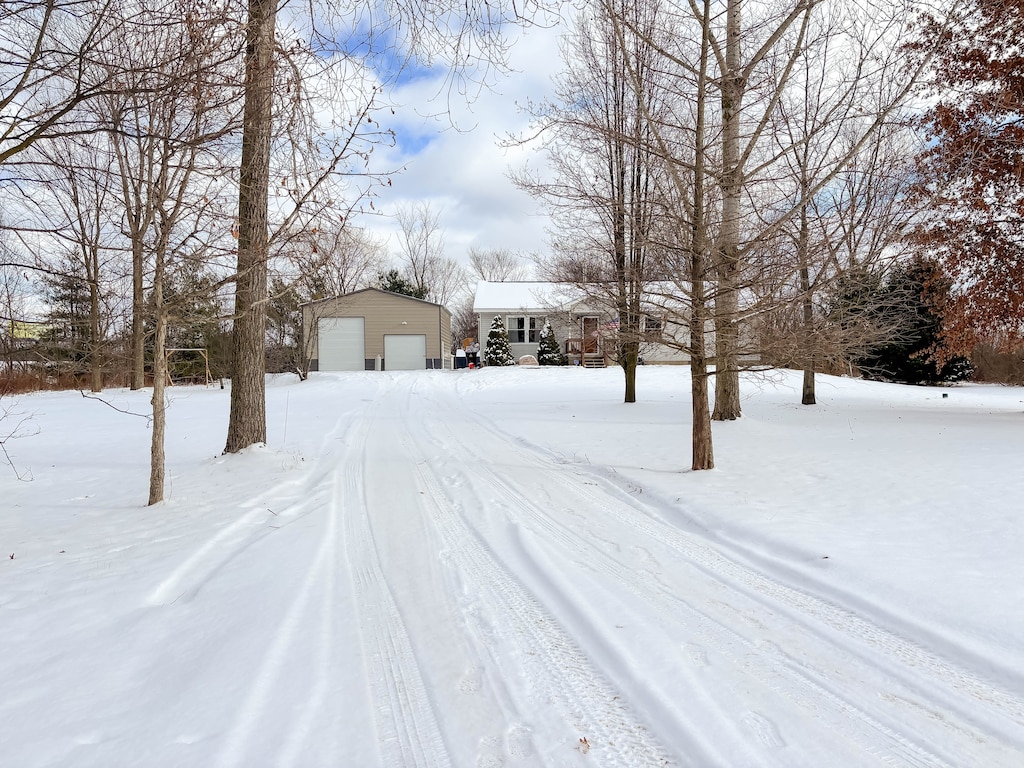 yard covered in snow with an outbuilding and a garage