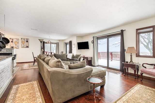 living room with a tile fireplace and dark hardwood / wood-style floors