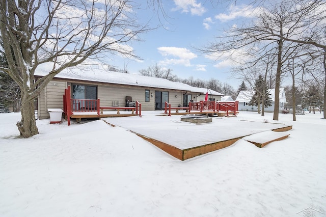 snow covered house with a wooden deck