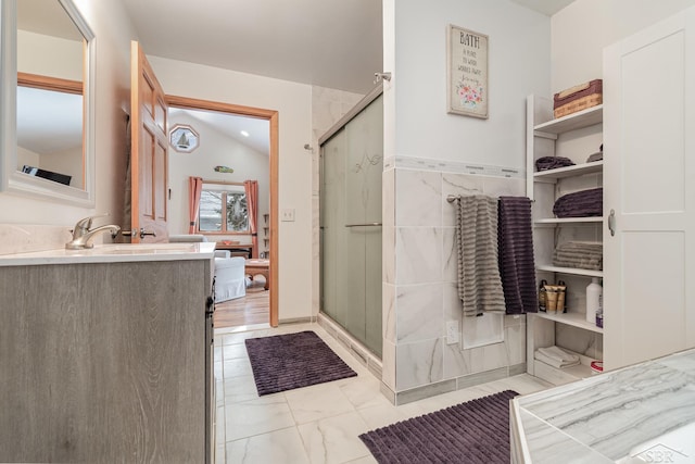 bathroom with vanity, a shower with shower door, and vaulted ceiling