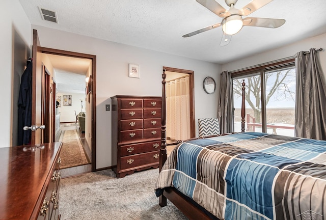 carpeted bedroom with a textured ceiling and ceiling fan