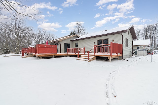 snow covered house with a wooden deck