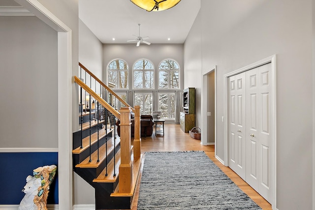 entryway featuring ceiling fan, light hardwood / wood-style flooring, and a high ceiling