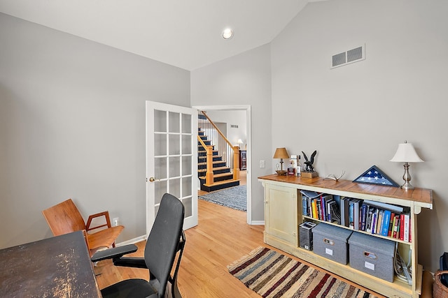 home office featuring light hardwood / wood-style floors and high vaulted ceiling