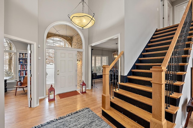 entryway with plenty of natural light, a high ceiling, and light wood-type flooring