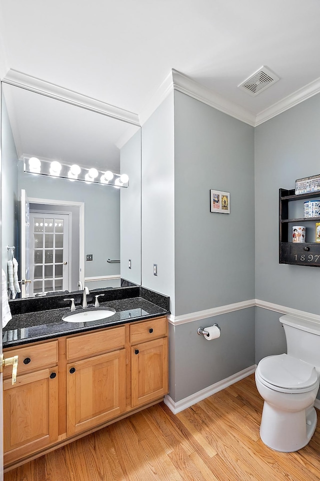 bathroom with hardwood / wood-style floors, vanity, toilet, and crown molding