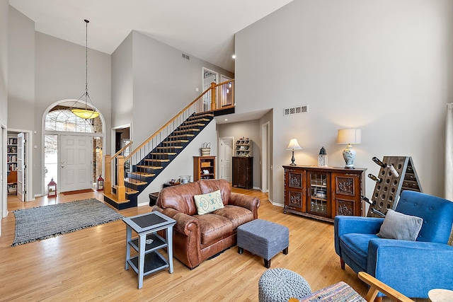 living room with light hardwood / wood-style floors and a high ceiling