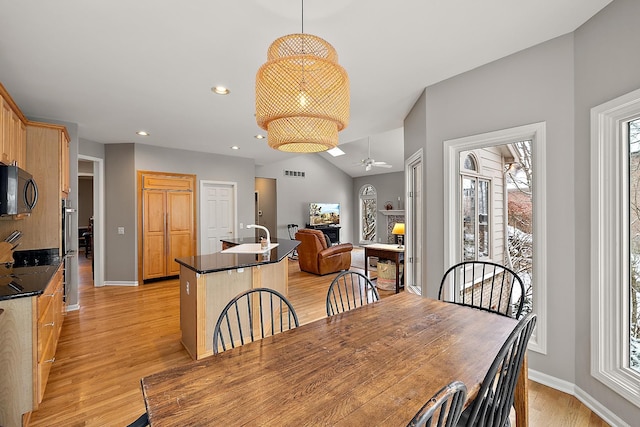 dining space featuring a wealth of natural light, light hardwood / wood-style floors, ceiling fan, and sink