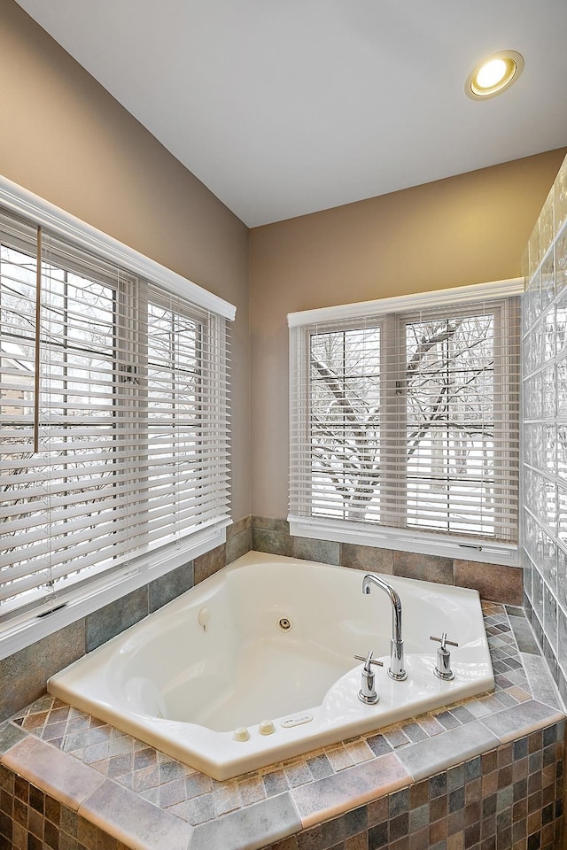 bathroom featuring a healthy amount of sunlight and tiled tub