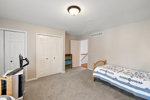 bedroom with carpet and two closets