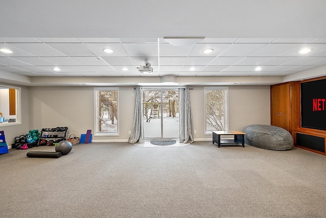 living area featuring a drop ceiling and carpet floors